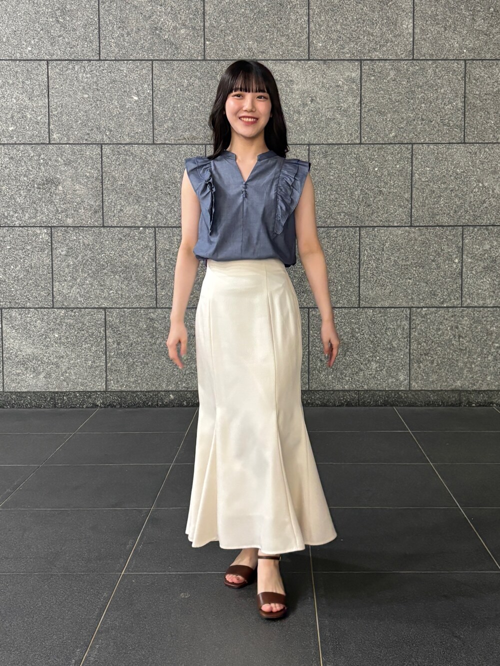 ブルー系のシャツ/ブラウス、ホワイト系のスカート、ブラウン系のサンダルを着用したレディースの夏コーディネートの3枚目の写真
