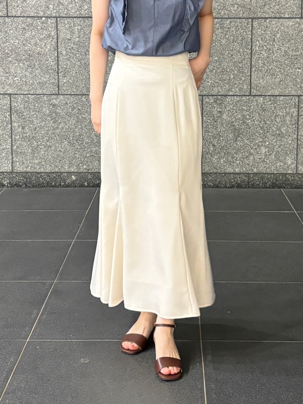 ブルー系のシャツ/ブラウス、ホワイト系のスカート、ブラウン系のサンダルを着用したレディースの夏コーディネートの6枚目の写真