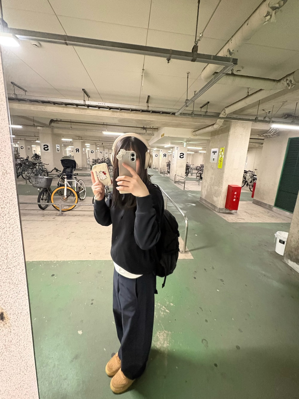 ブラウン系のスニーカー、グレー系のスウェット、ブラック系のデニムパンツを着用したレディースの春コーディネートの2枚目の写真