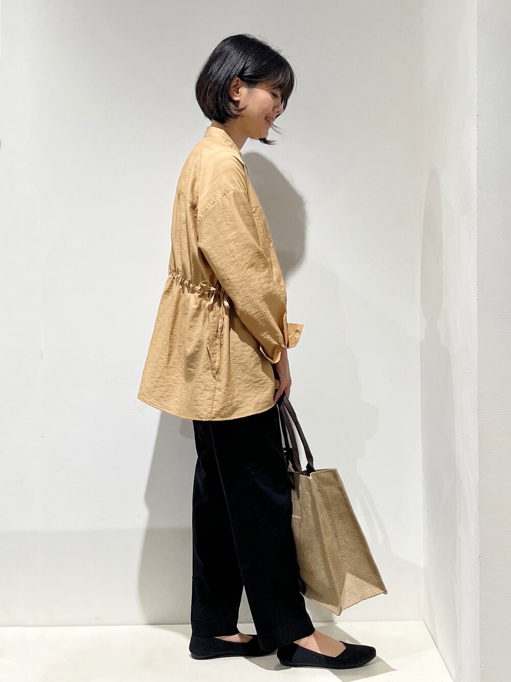 イエロー系のシャツ/ブラウス、ホワイト系のニット/セーター、ブラック系のその他パンツを着用したレディースの春コーディネートの2枚目の写真