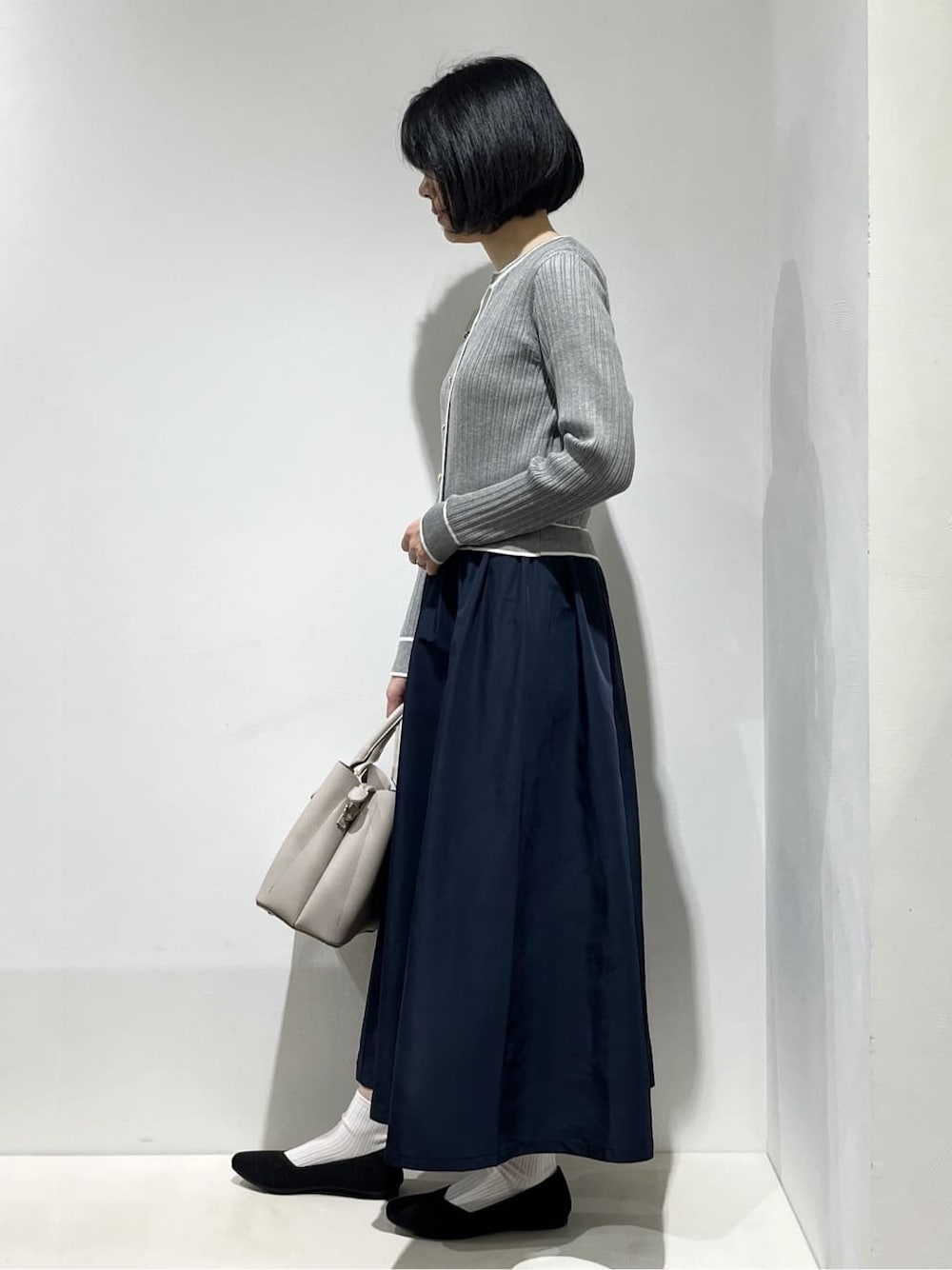 グレー系のワンピース、ホワイト系のタンクトップ、グレー系のトートバッグを着用したレディースの春コーディネートの2枚目の写真