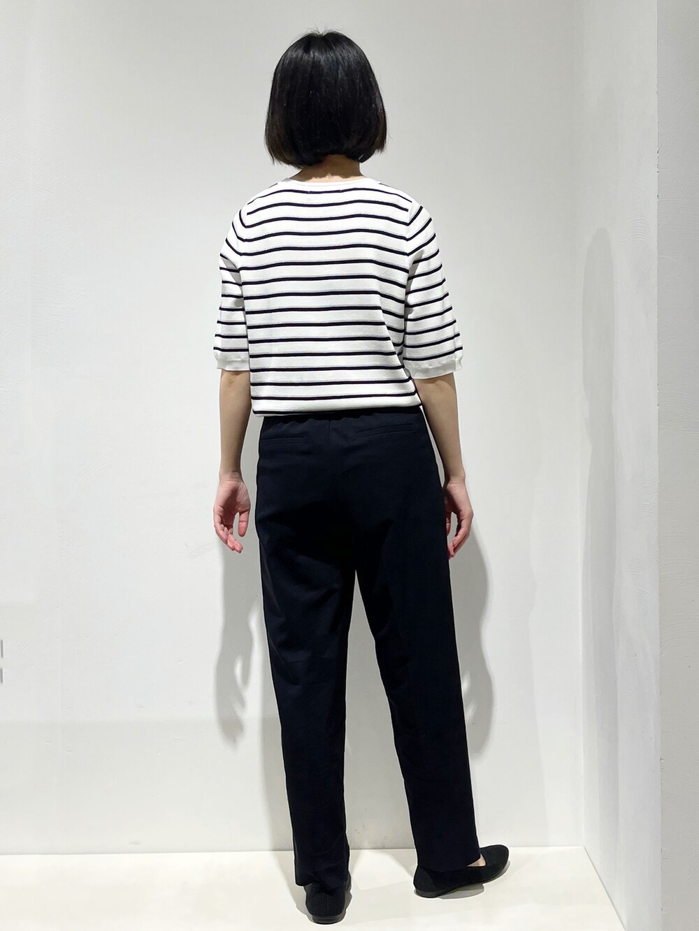 イエロー系のシャツ/ブラウス、ホワイト系のニット/セーター、ブラック系のその他パンツを着用したレディースの春コーディネートの6枚目の写真