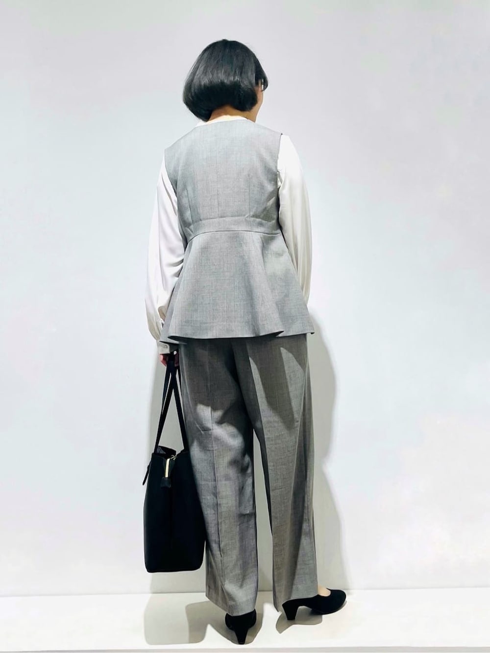 グレー系のベスト、ホワイト系のシャツ/ブラウス、グレー系のその他パンツを着用したレディースの冬コーディネートの3枚目の写真
