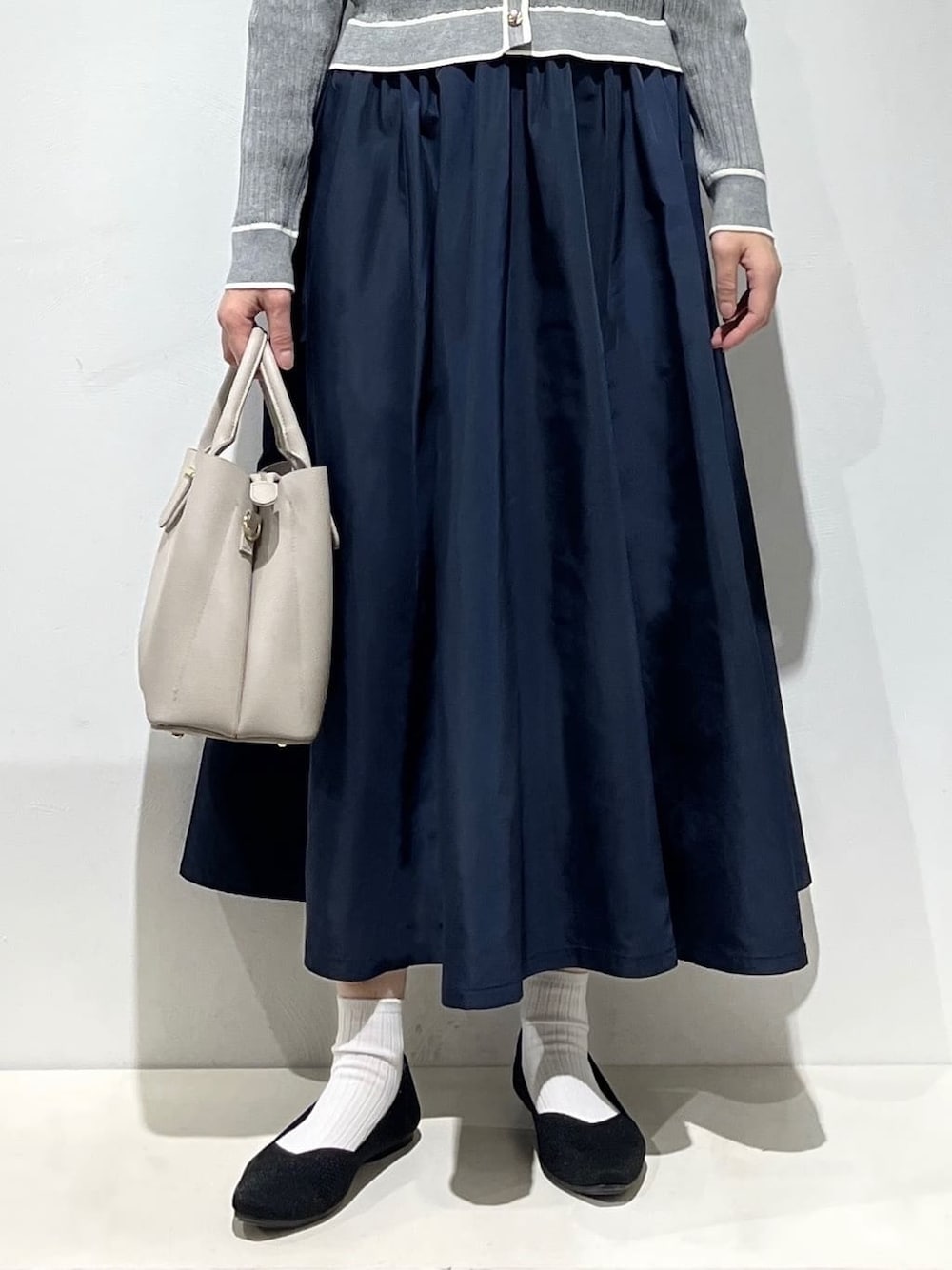 グレー系のワンピース、ホワイト系のタンクトップ、グレー系のトートバッグを着用したレディースの春コーディネートの6枚目の写真