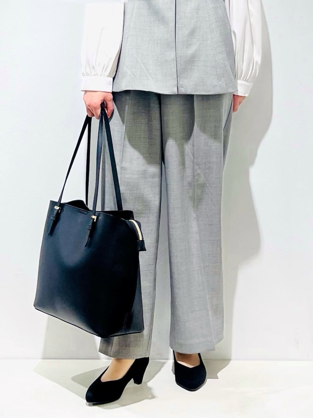 グレー系のベスト、ホワイト系のシャツ/ブラウス、グレー系のその他パンツを着用したレディースの冬コーディネートの6枚目の写真