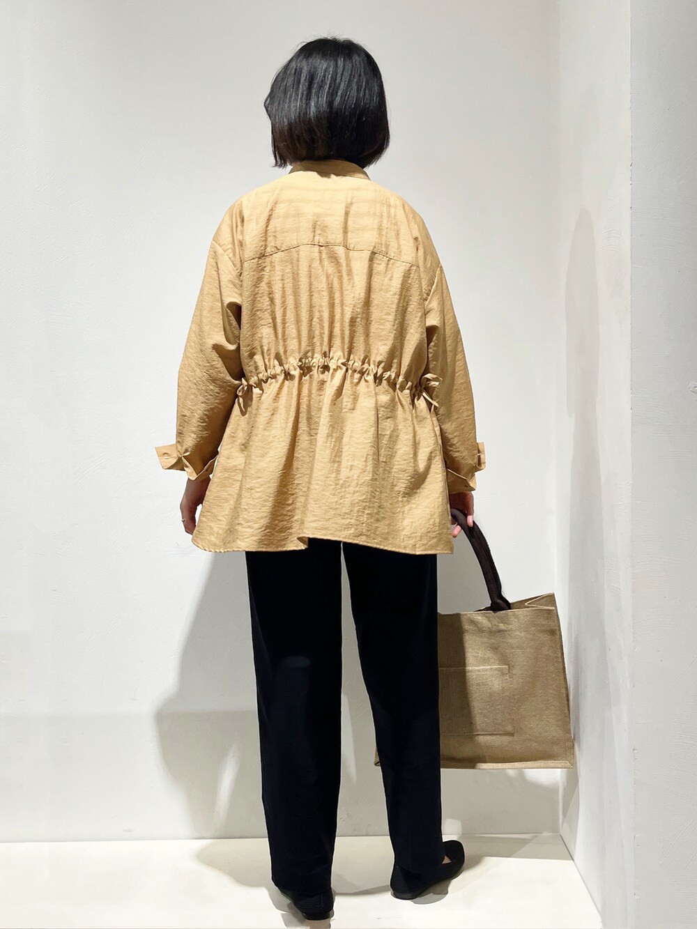 イエロー系のシャツ/ブラウス、ホワイト系のニット/セーター、ブラック系のその他パンツを着用したレディースの春コーディネートの3枚目の写真