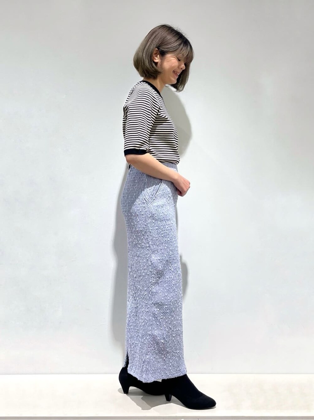 ブルー系のブルゾン、ブラック系のニット/セーター、ブルー系のスカートを着用したレディースの春コーディネートの5枚目の写真