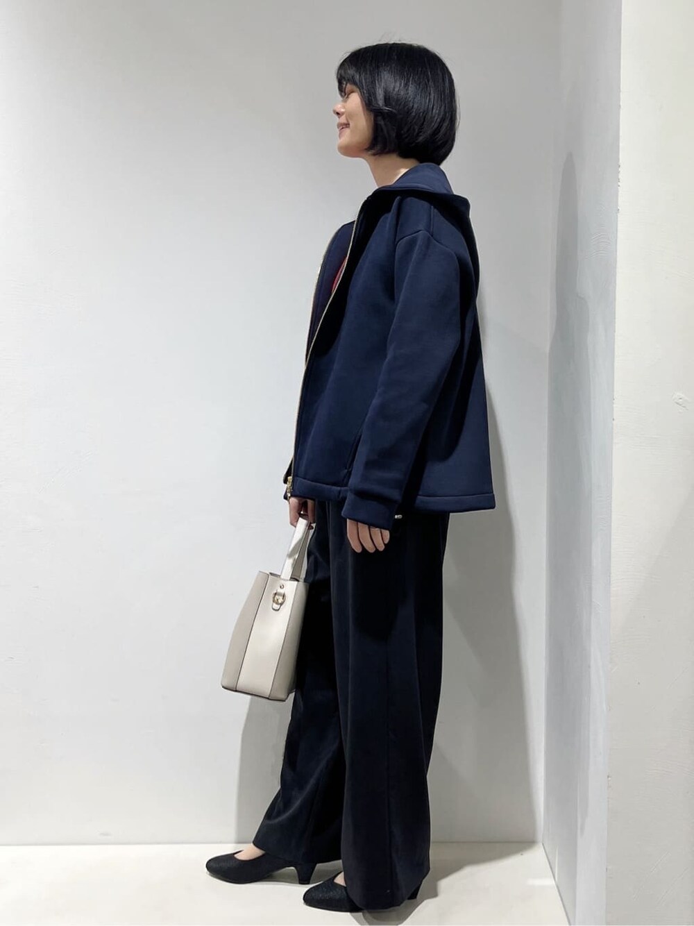 ブルー系のブルゾン、レッド系のニット/セーター、ブラック系のその他パンツを着用したレディースの春コーディネートの2枚目の写真