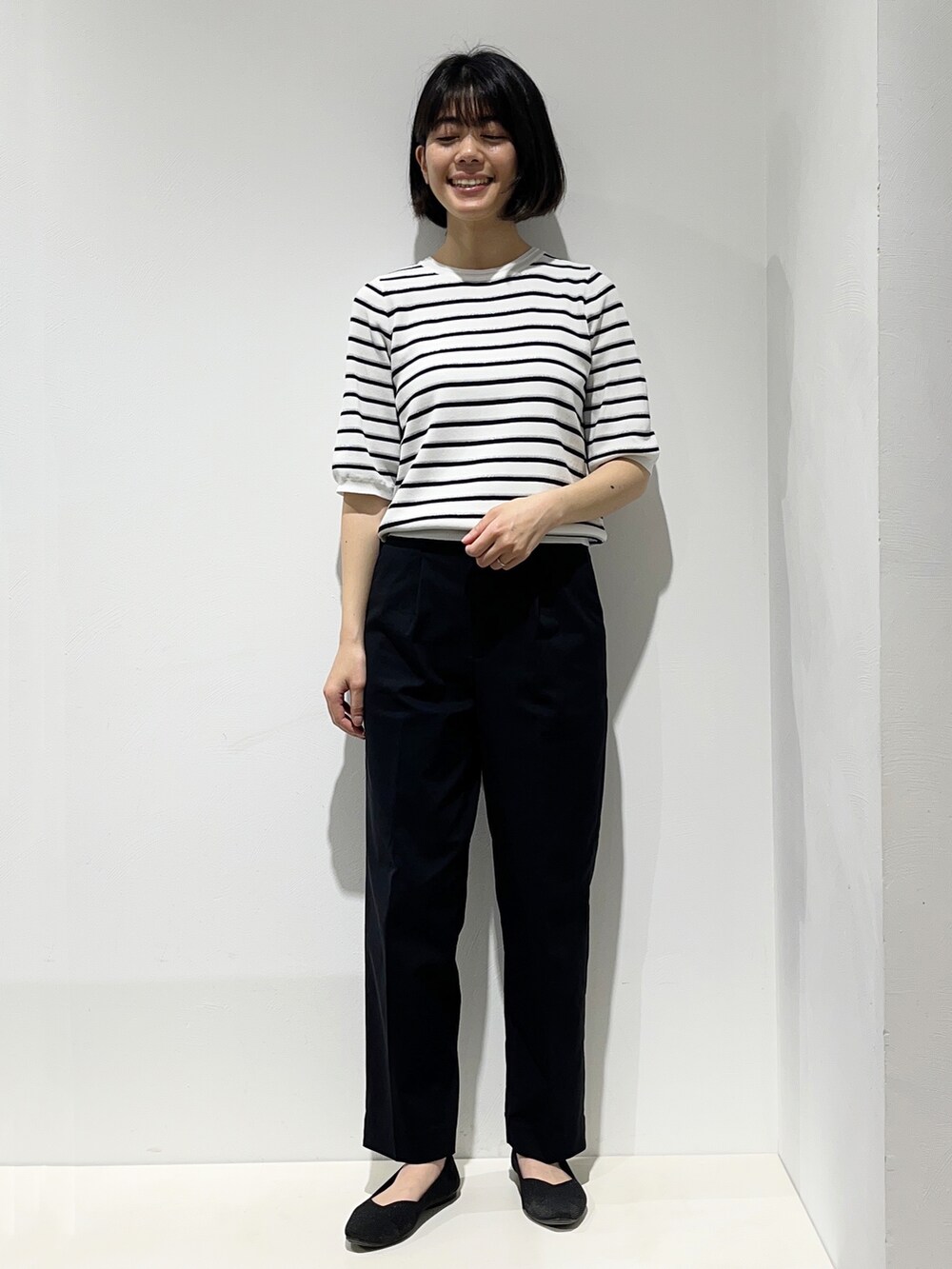 イエロー系のシャツ/ブラウス、ホワイト系のニット/セーター、ブラック系のその他パンツを着用したレディースの春コーディネートの4枚目の写真