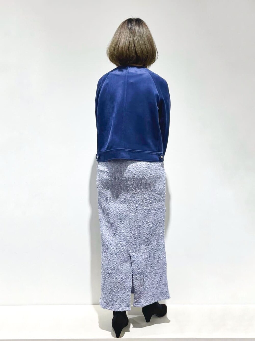 ブルー系のブルゾン、ブラック系のニット/セーター、ブルー系のスカートを着用したレディースの春コーディネートの3枚目の写真