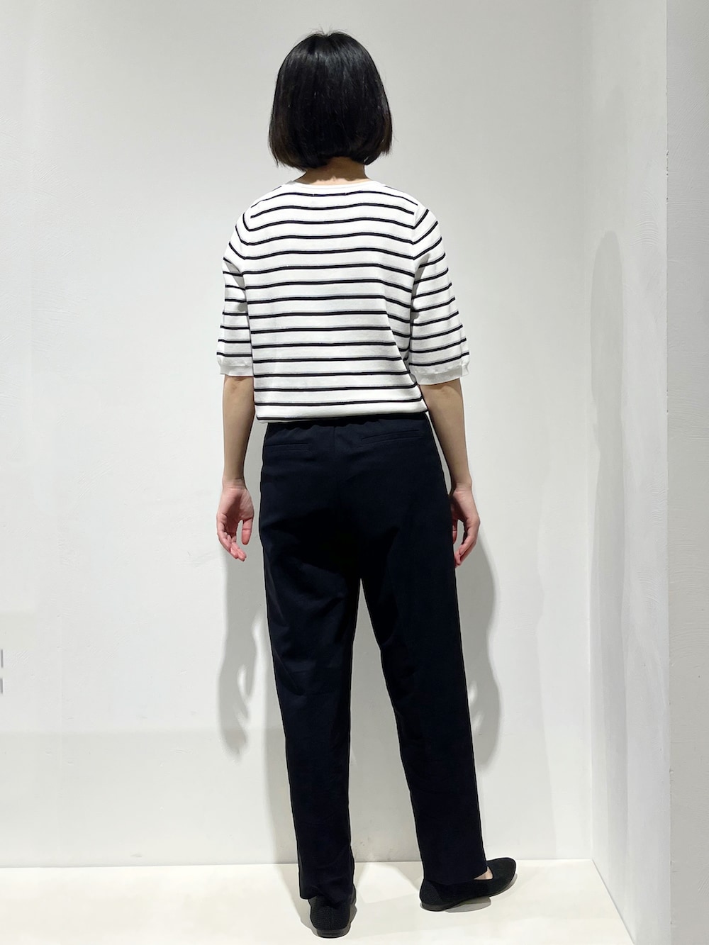 グリーン系のトートバッグ、ブラック系のパンプス、ブラック系のその他パンツを着用したレディースの春コーディネートの6枚目の写真