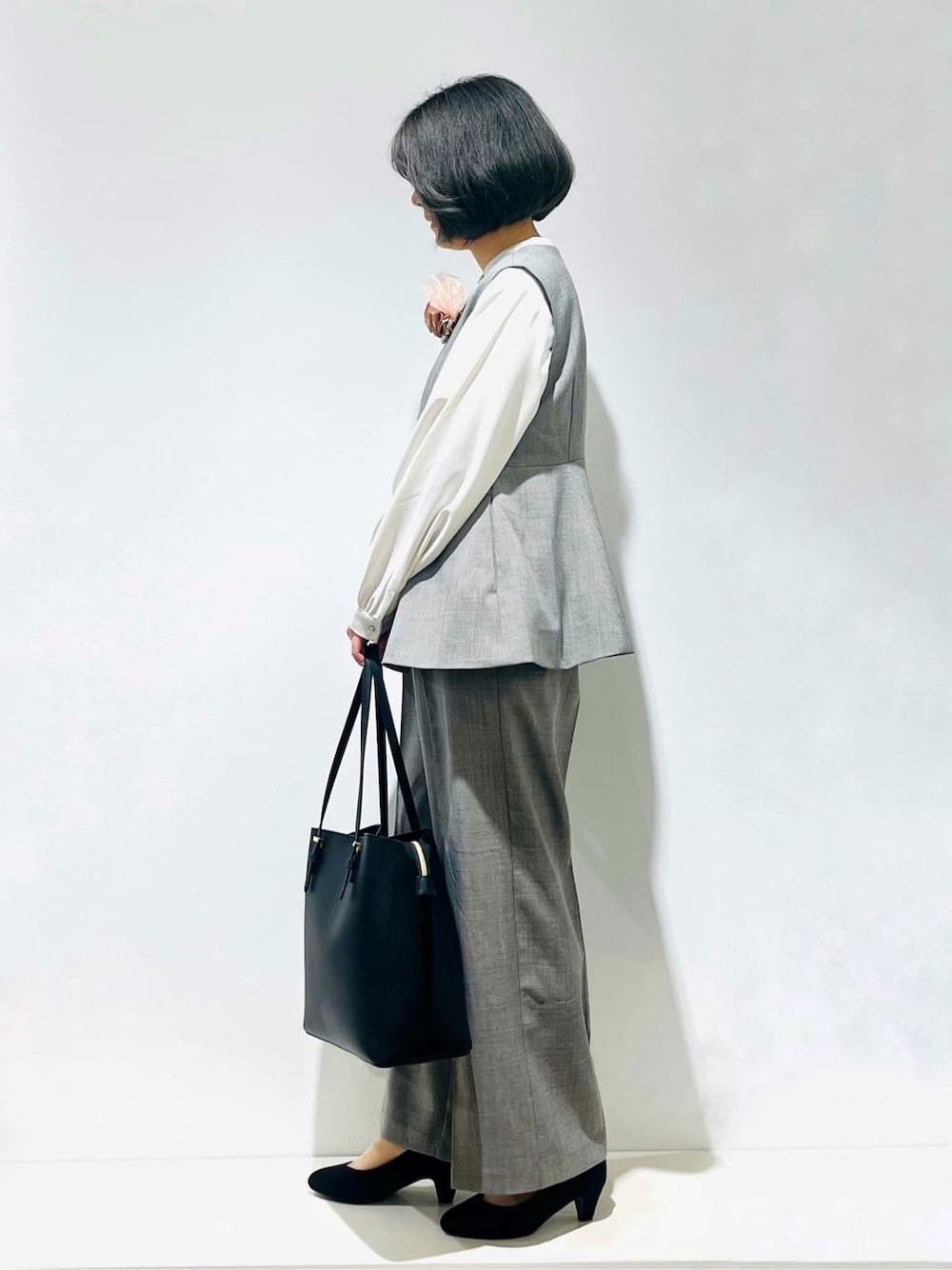 グレー系のベスト、ホワイト系のシャツ/ブラウス、グレー系のその他パンツを着用したレディースの冬コーディネートの4枚目の写真