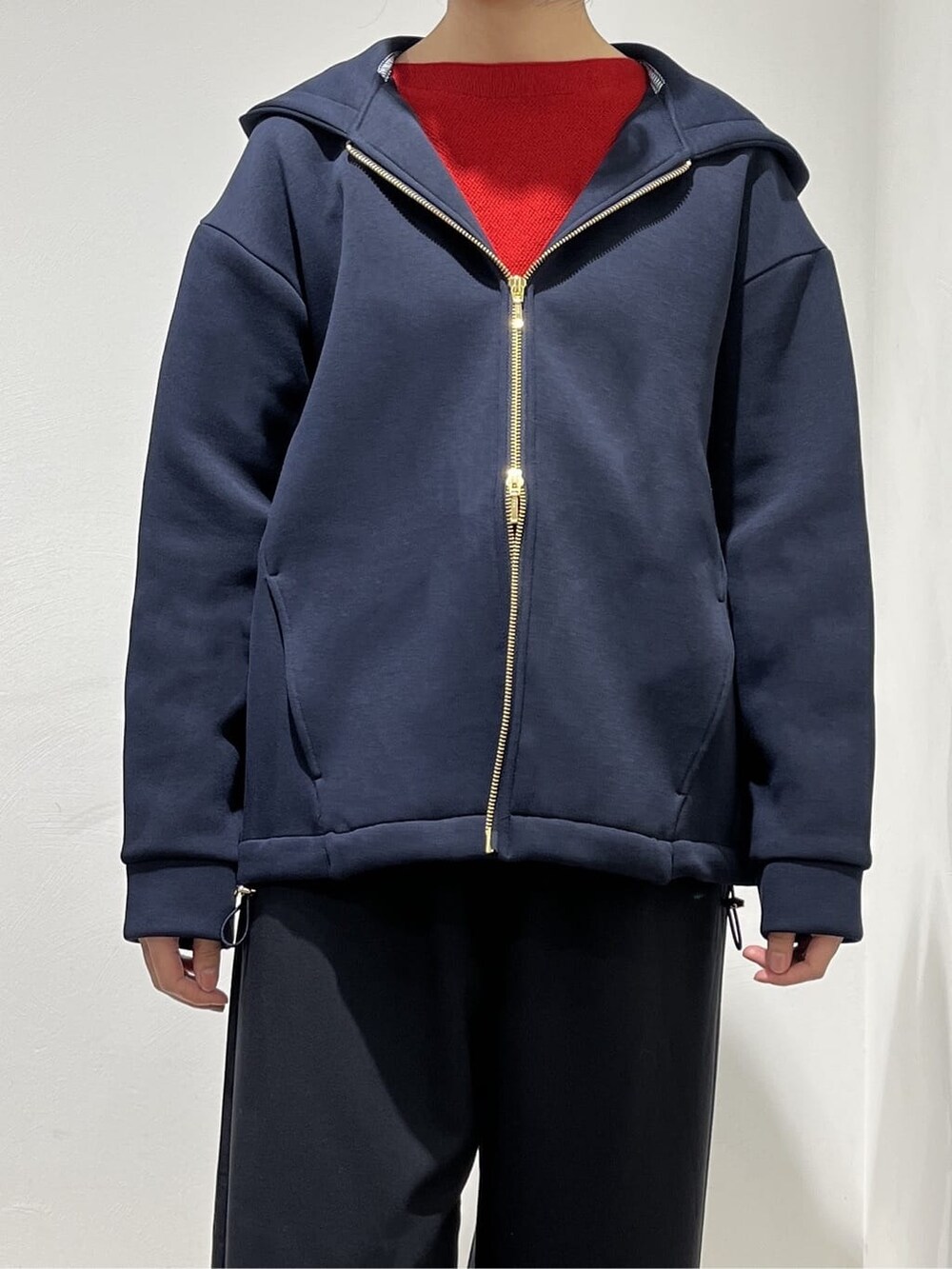 ブルー系のブルゾン、レッド系のニット/セーター、ブラック系のその他パンツを着用したレディースの春コーディネートの4枚目の写真