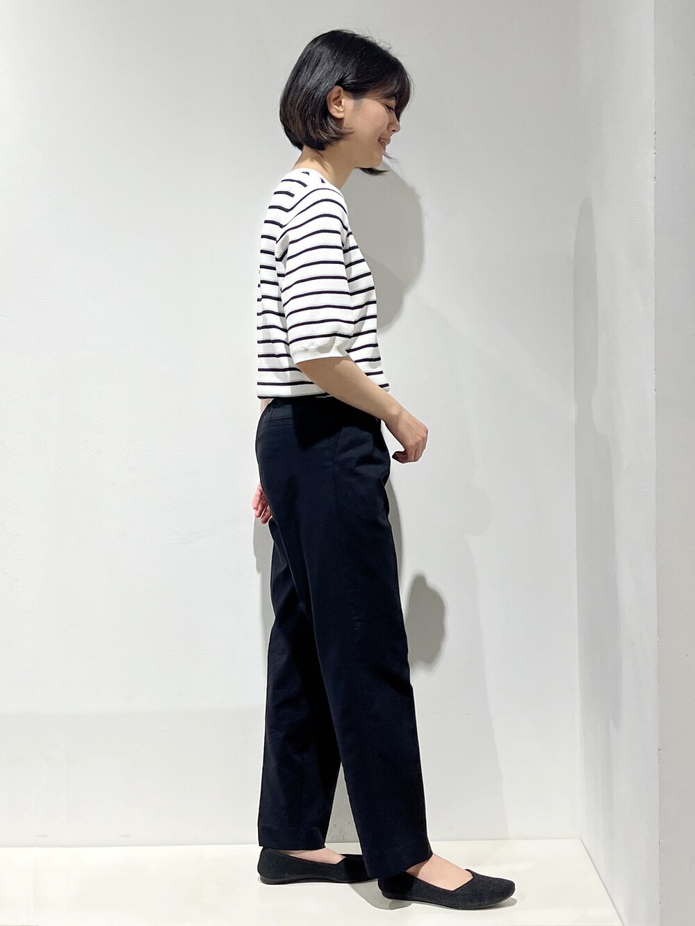 イエロー系のシャツ/ブラウス、ホワイト系のニット/セーター、ブラック系のその他パンツを着用したレディースの春コーディネートの5枚目の写真