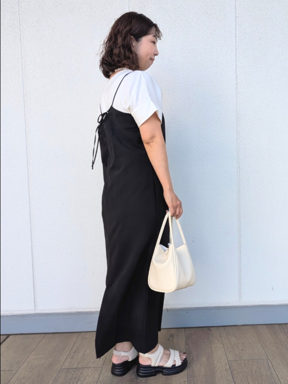 ホワイト系のサンダル、ホワイト系のショルダーバッグ、ホワイト系のTシャツ/カットソーを着用したレディースの夏コーディネートの2枚目の写真