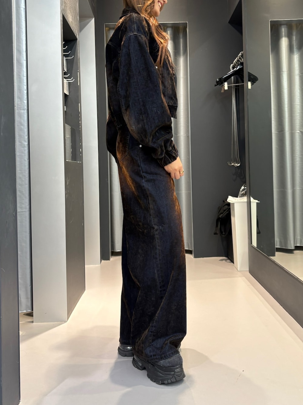 ブラウン系のデニムパンツ、ブラウン系のブルゾン、ブラック系のスニーカーを着用したレディースの夏コーディネートの2枚目の写真