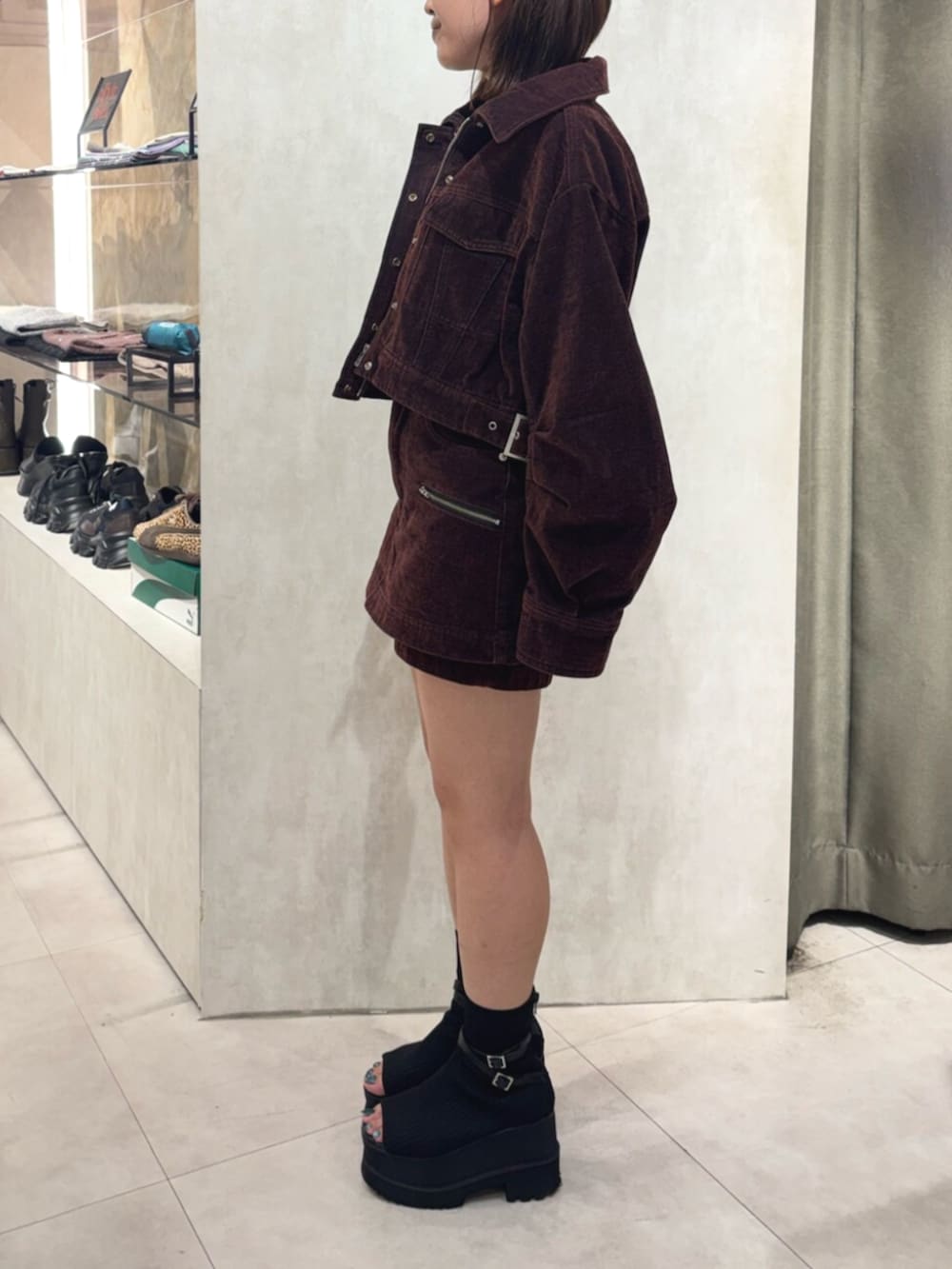 レッド系のデニムジャケット、レッド系のデニムスカート、ブラック系のTシャツ/カットソーを着用したレディースの秋コーディネートの2枚目の写真