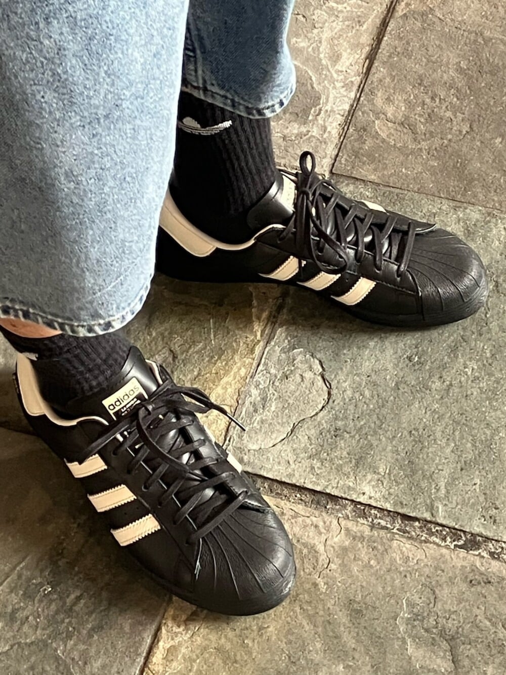 ブルー系のデニムパンツ、ブルー系のデニムジャケット、ブラック系のスニーカーを着用したメンズの秋コーディネートの4枚目の写真
