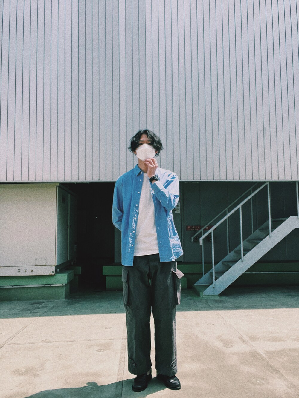 ホワイト系のパンツ、ブラック系のローファーを着用したメンズの春コーディネートの2枚目の写真