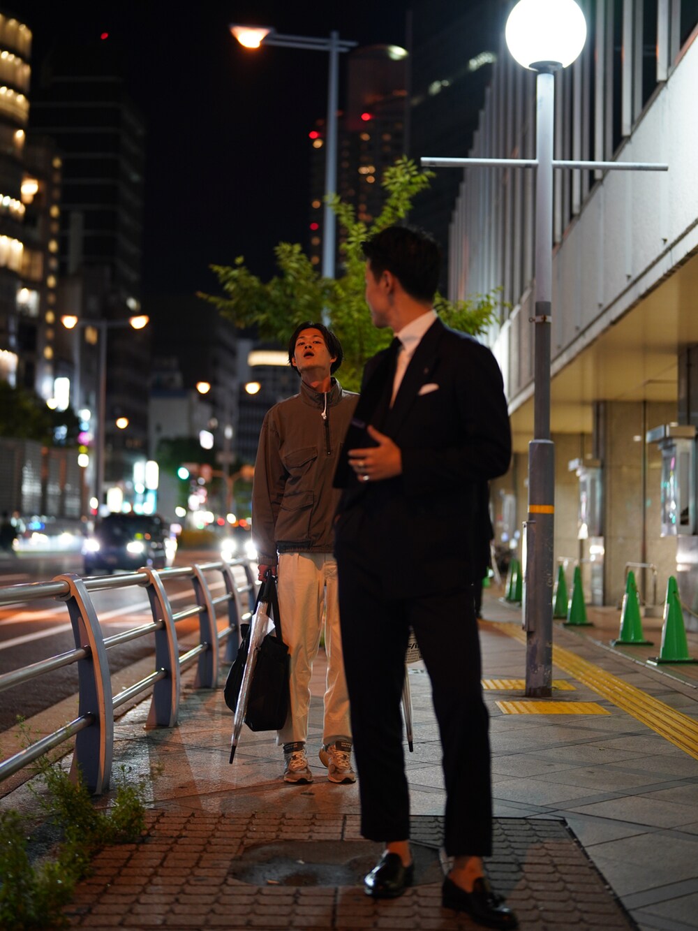 グレー系のナイロンジャケット、ホワイト系のパンツ、グレー系のスニーカーを着用したメンズの冬コーディネートの2枚目の写真