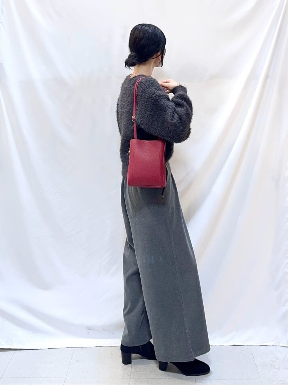 グレー系のニット/セーター、グレー系のその他パンツ、ブラック系のブーツを着用したレディースの冬コーディネートの3枚目の写真