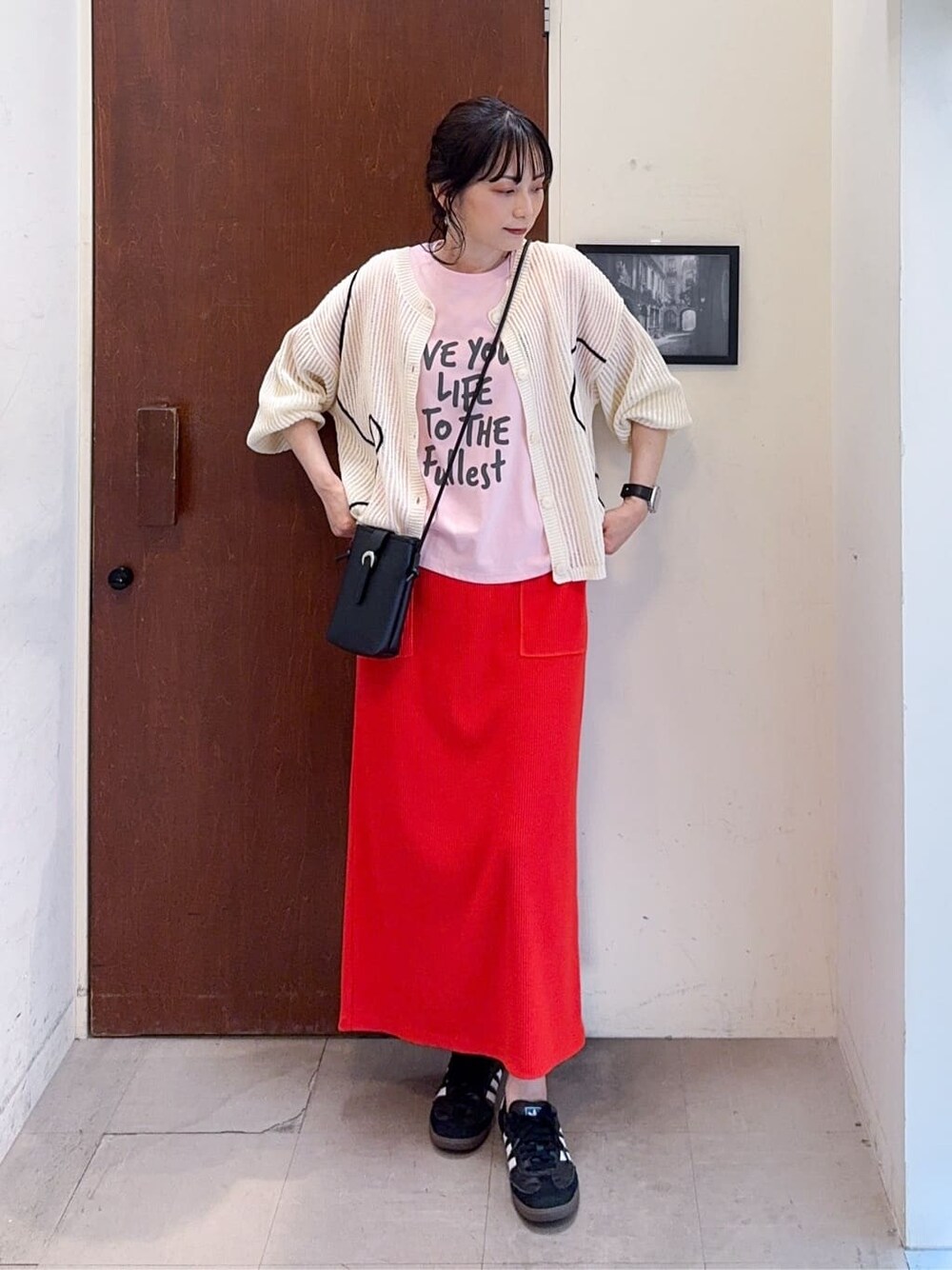 ホワイト系のカーディガン/ボレロ、ピンク系のTシャツ/カットソー、オレンジ系のスカートを着用したレディースの春コーディネートの2枚目の写真
