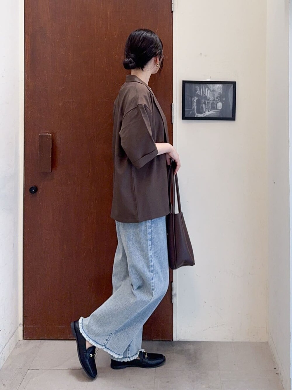 ブラウン系のテーラードジャケット、イエロー系のTシャツ/カットソー、ブルー系のデニムパンツを着用したレディースの秋コーディネートの3枚目の写真
