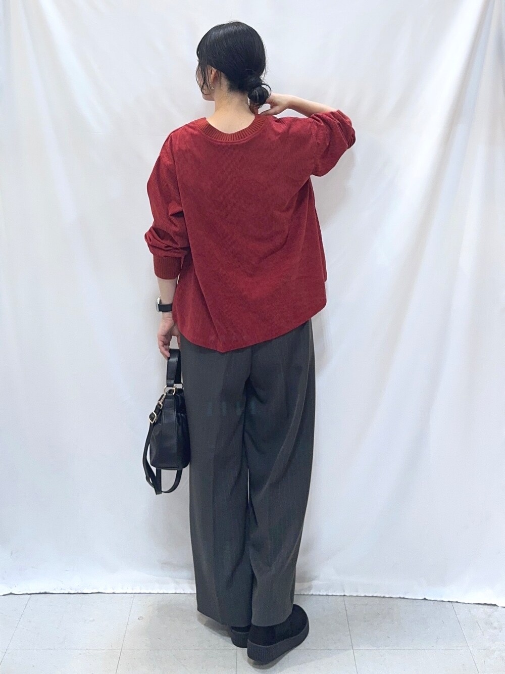 レッド系のTシャツ/カットソー、グレー系のその他パンツ、ブラック系のブーツを着用したレディースの秋コーディネートの3枚目の写真