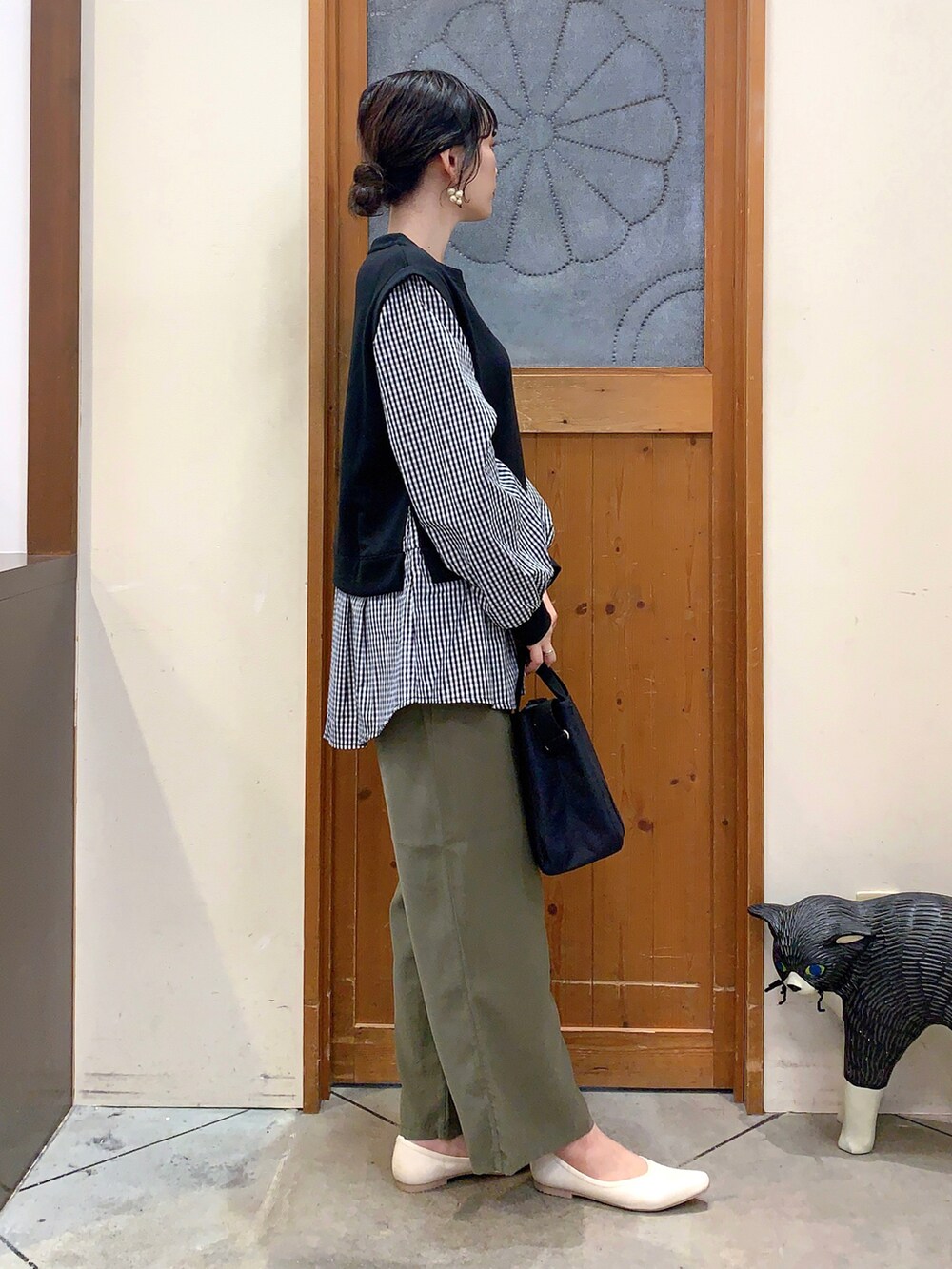 ブラック系のTシャツ/カットソー、グリーン系のその他パンツ、ブラック系のトートバッグを着用したレディースの春コーディネートの2枚目の写真