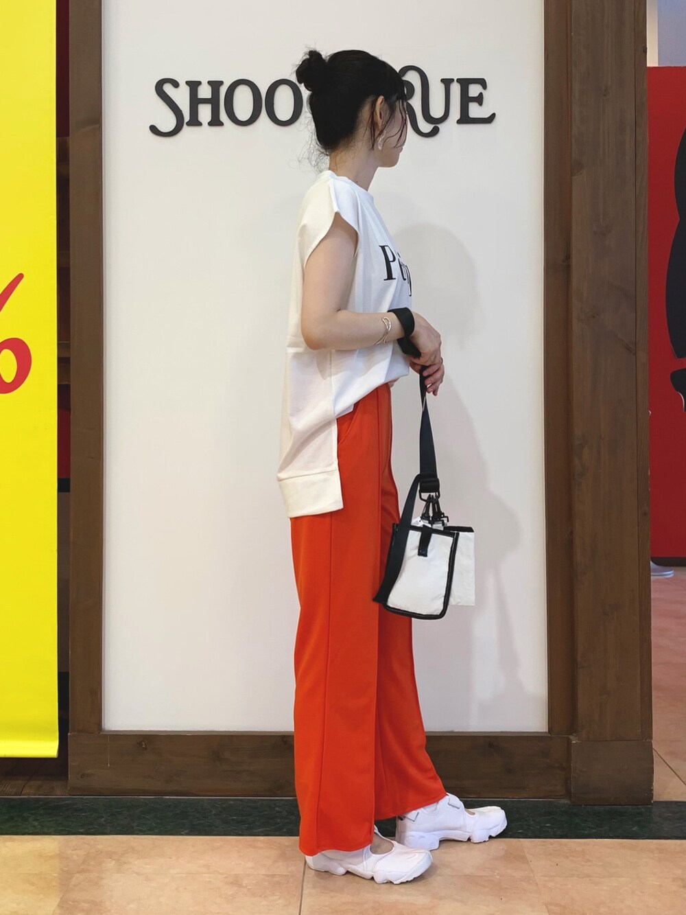 ホワイト系のTシャツ/カットソー、オレンジ系のその他パンツ、ホワイト系のショルダーバッグを着用したレディースの夏コーディネートの2枚目の写真