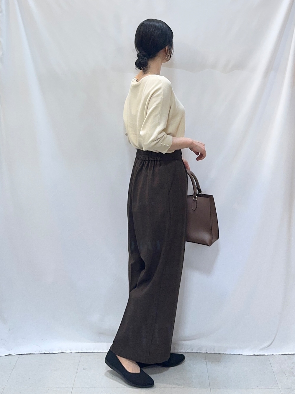 ホワイト系のニット/セーター、ブラウン系のその他パンツ、ブラック系のパンプスを着用したレディースの秋コーディネートの2枚目の写真