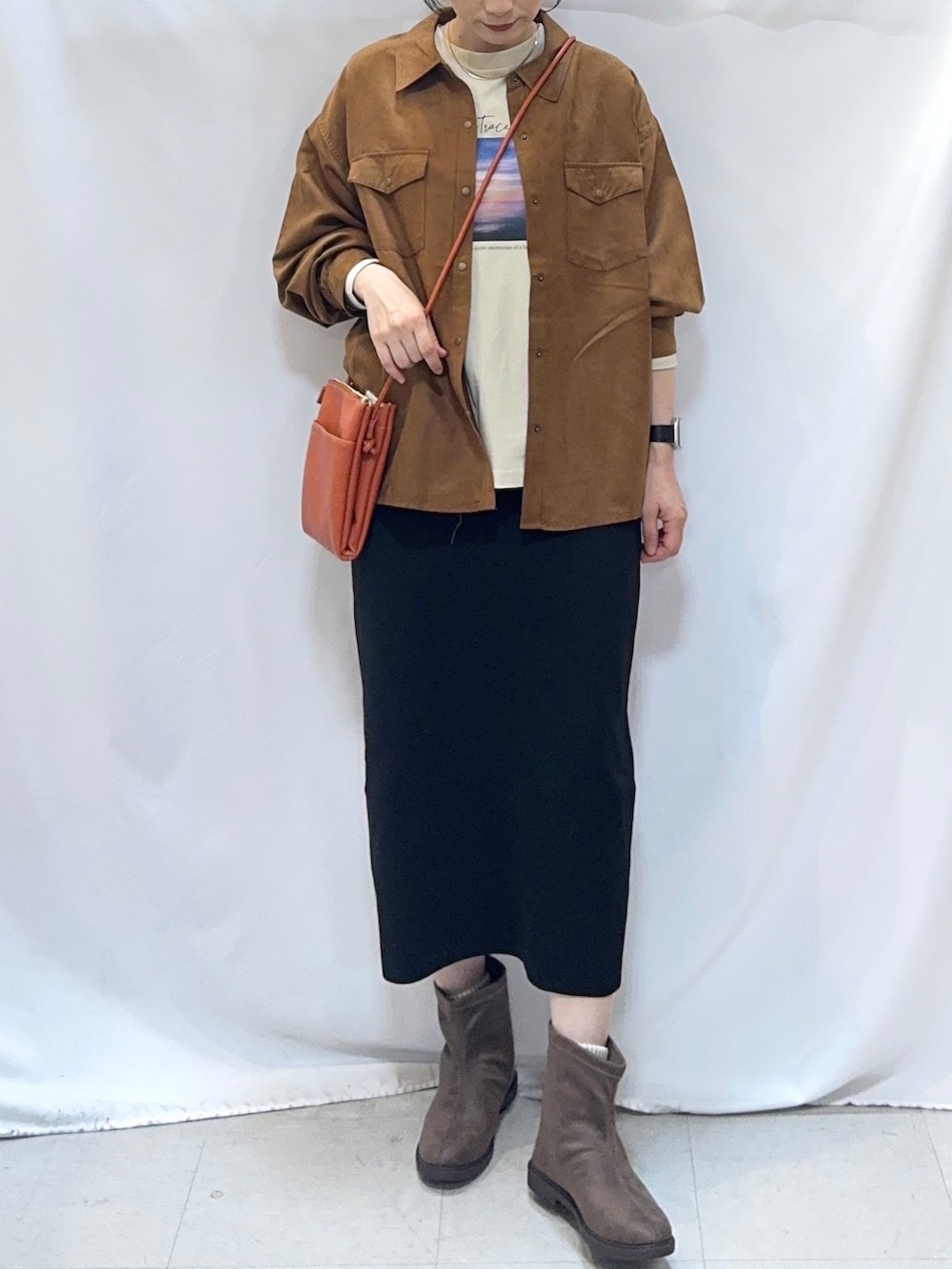 イエロー系のシャツ/ブラウス、ベージュ系のTシャツ/カットソー、ブラック系のスカートを着用したレディースの秋コーディネートの5枚目の写真