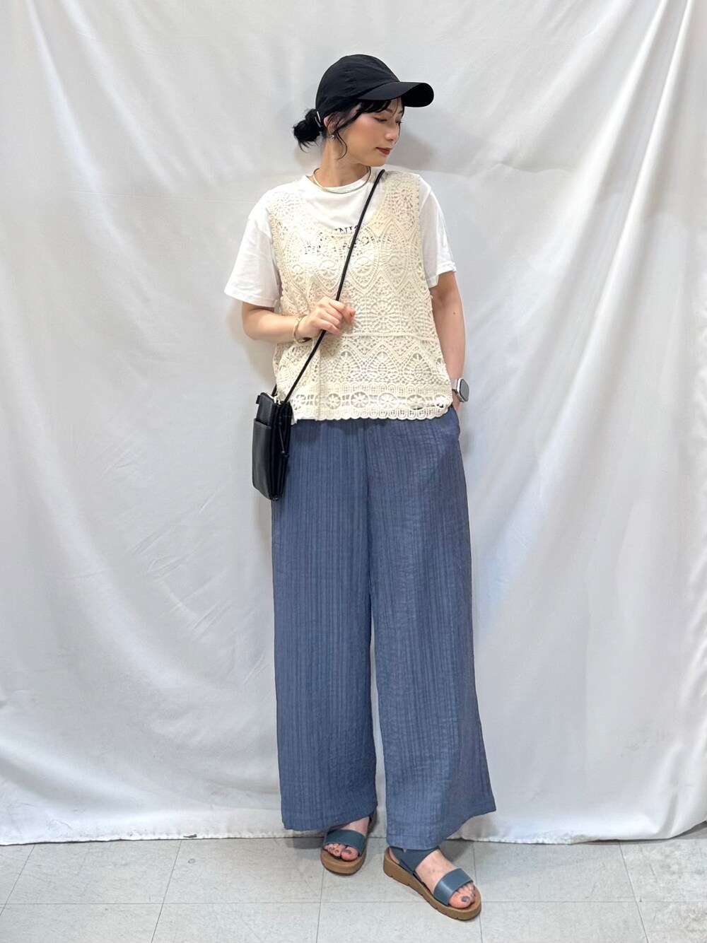 ブルー系のその他パンツ、ブルー系のサンダル、ブラック系のショルダーバッグを着用したレディースの夏コーディネートの2枚目の写真