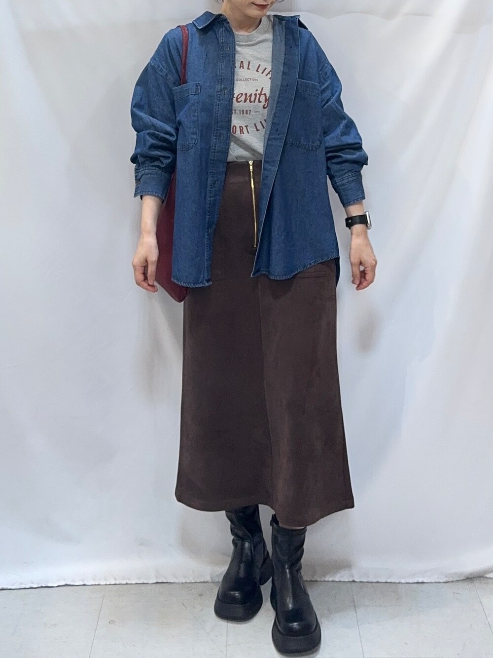 ブルー系のシャツ/ブラウス、グレー系のTシャツ/カットソー、ブラウン系のスカートを着用したレディースの秋コーディネートの5枚目の写真
