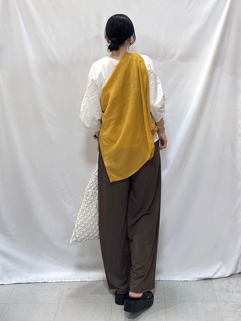 イエロー系のシャツ/ブラウス、ホワイト系のTシャツ/カットソー、ブラウン系のその他パンツを着用したレディースの夏コーディネートの5枚目の写真