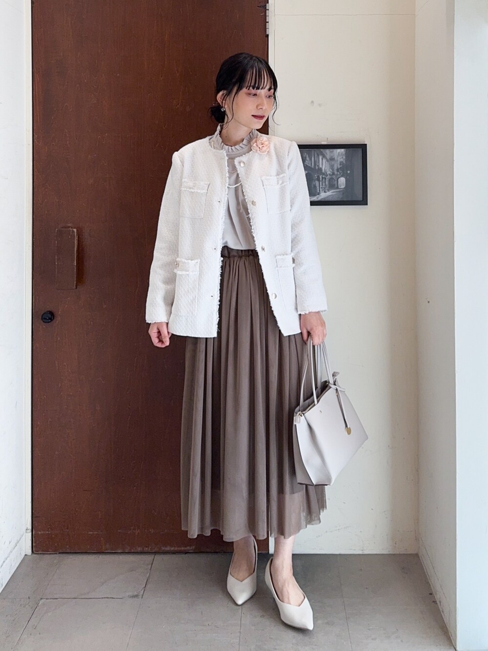 ベージュ系のノーカラージャケット、ベージュ系のシャツ/ブラウス、ブラウン系のスカートを着用したレディースの冬コーディネートの2枚目の写真