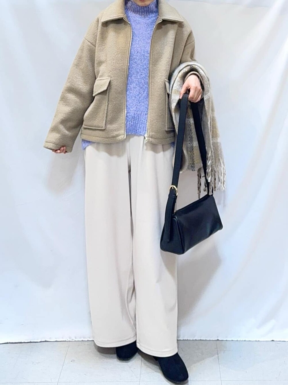 ベージュ系のブルゾン、ブルー系のニット/セーター、ホワイト系のその他パンツを着用したレディースの冬コーディネートの5枚目の写真