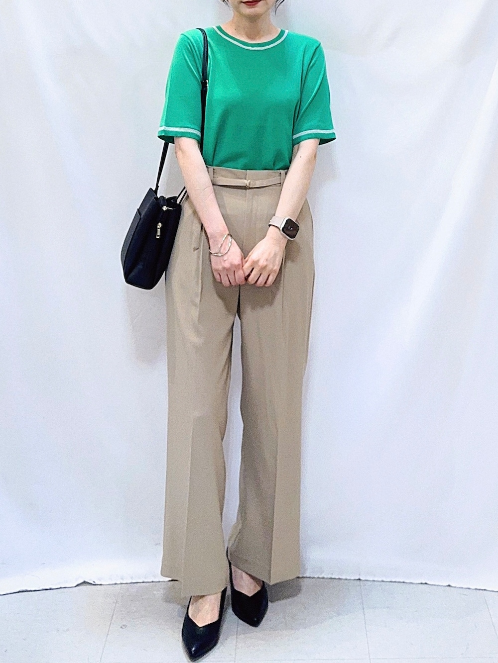 グリーン系のニット/セーター、ベージュ系のその他パンツ、ブラック系のパンプスを着用したレディースの夏コーディネートの5枚目の写真