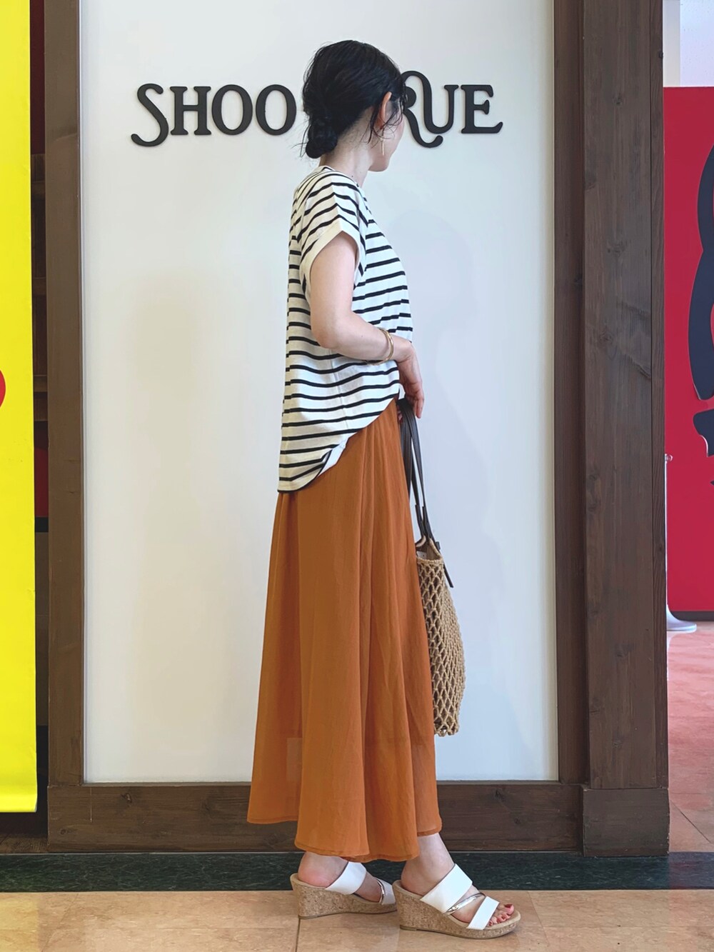 ホワイト系のTシャツ/カットソー、ブラウン系のトートバッグ、ベージュ系のサンダルを着用したレディースの夏コーディネートの2枚目の写真