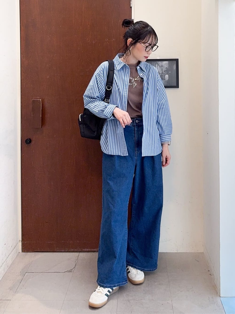 ブルー系のシャツ/ブラウス、ブラウン系のTシャツ/カットソー、ブルー系のデニムパンツを着用したレディースの春コーディネートの2枚目の写真
