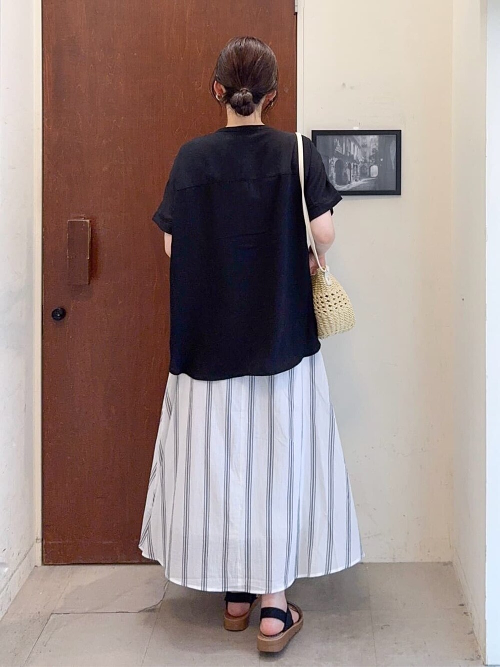 ブラック系のシャツ/ブラウス、ホワイト系のスカート、ブラック系のサンダルを着用したレディースの夏コーディネートの4枚目の写真