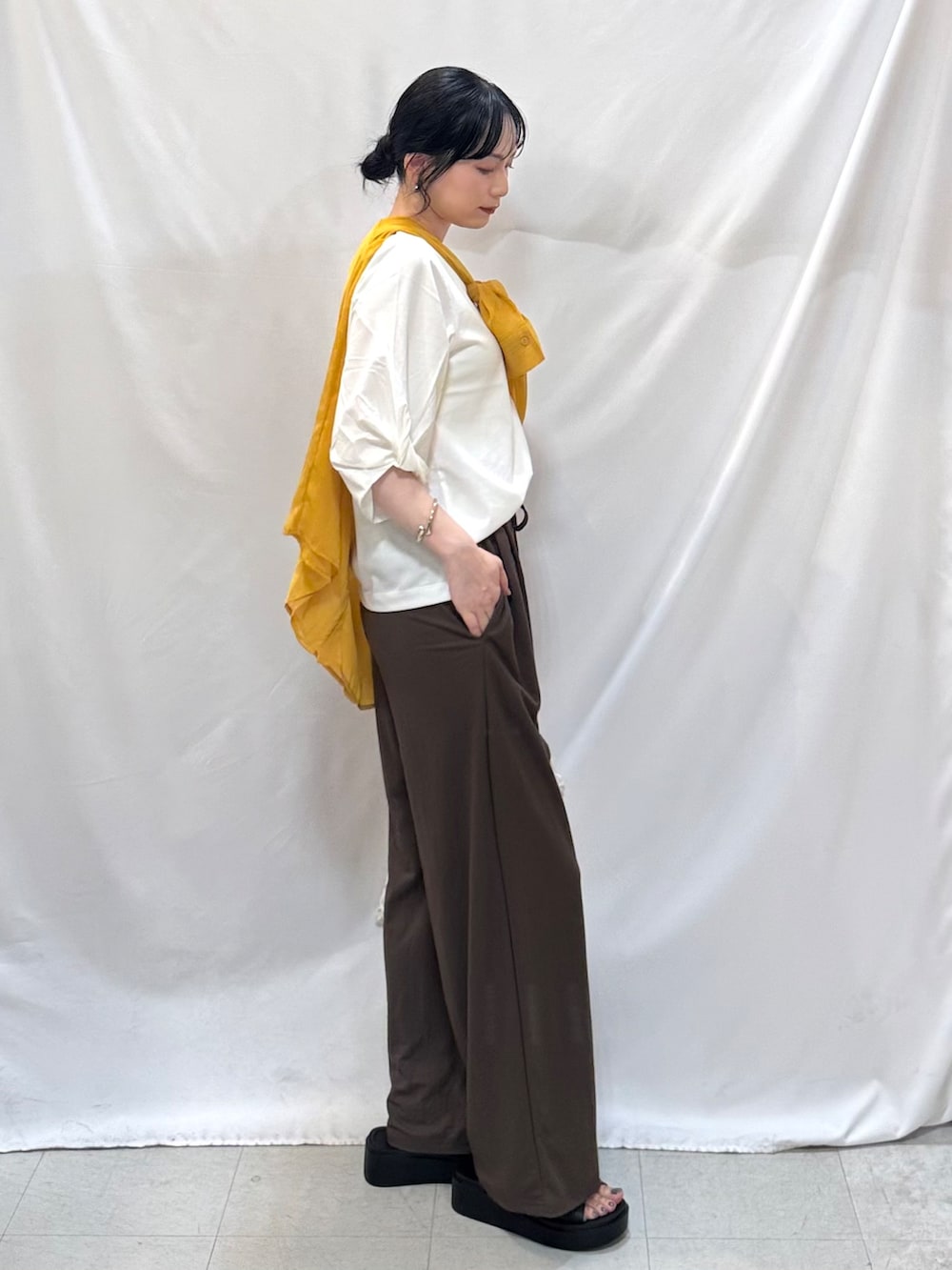 イエロー系のシャツ/ブラウス、ホワイト系のTシャツ/カットソー、ブラウン系のその他パンツを着用したレディースの夏コーディネートの3枚目の写真
