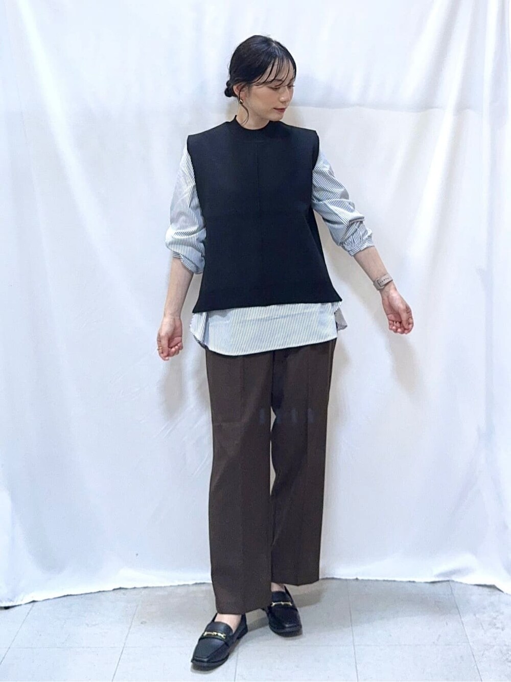 グリーン系のカーディガン/ボレロ、ブラック系のニット/セーター、ブラウン系のその他パンツを着用したレディースの秋コーディネートの6枚目の写真