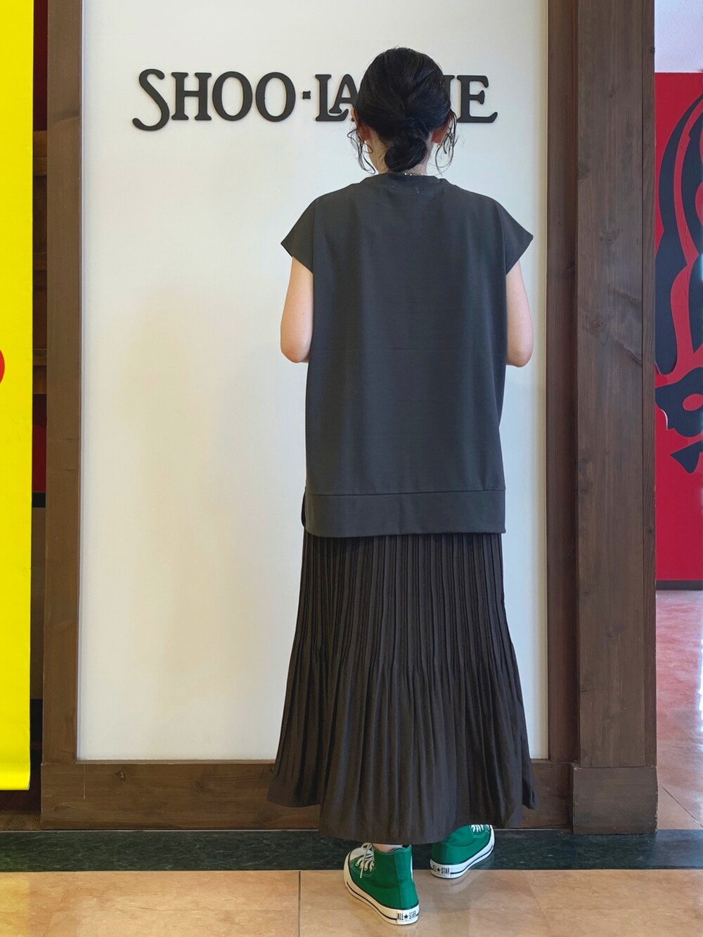 グレー系のTシャツ/カットソー、ブラウン系のスカート、ブラック系のトートバッグを着用したレディースの夏コーディネートの3枚目の写真