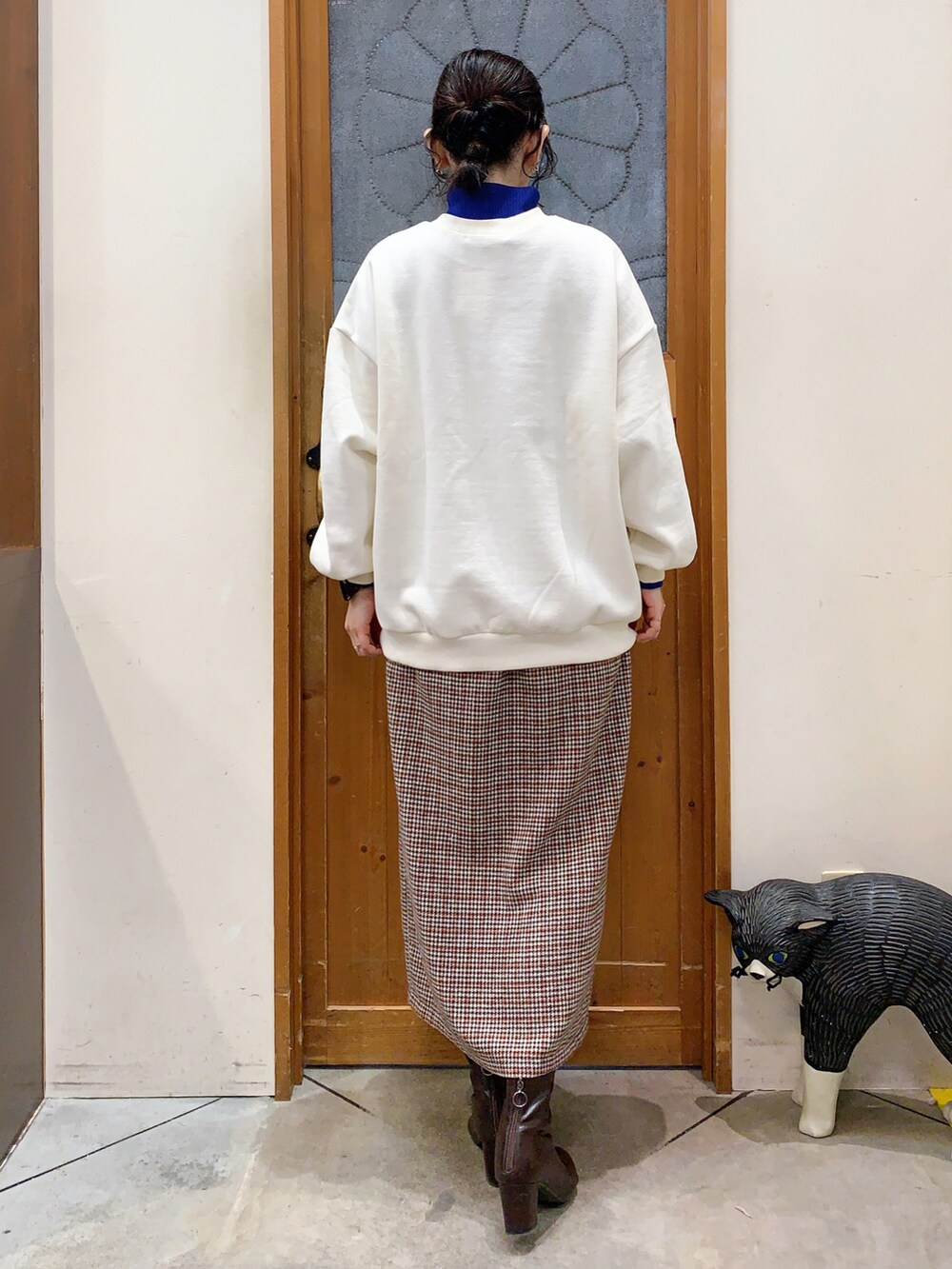 ホワイト系のスウェット、ブルー系のニット/セーター、ベージュ系のスカートを着用したレディースの冬コーディネートの4枚目の写真