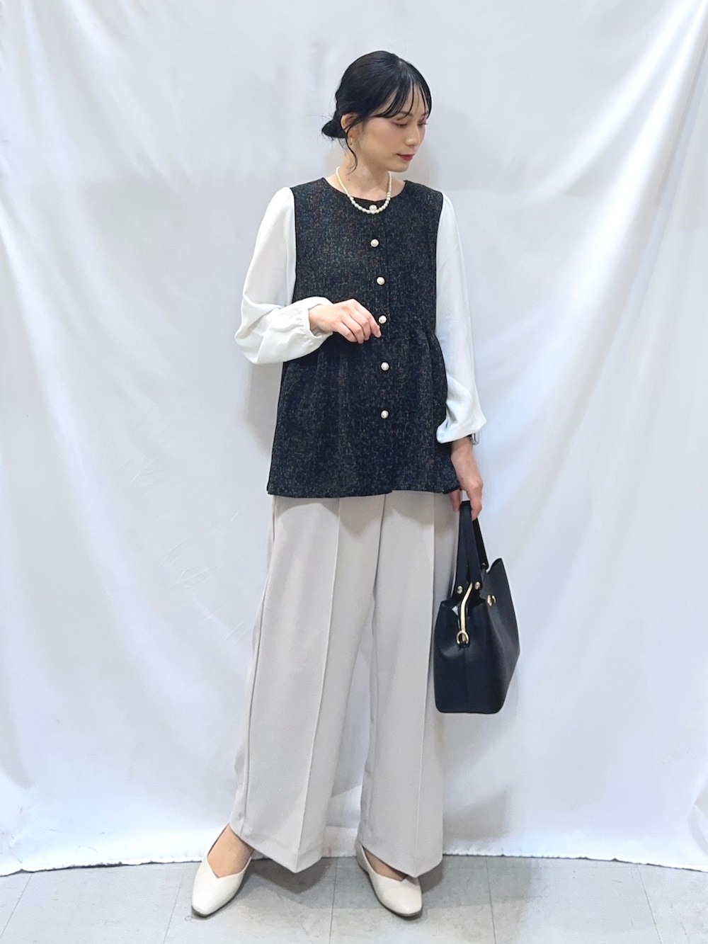 ブラック系のシャツ/ブラウス、ベージュ系のその他パンツ、ホワイト系のパンプスを着用したレディースの冬コーディネートの2枚目の写真