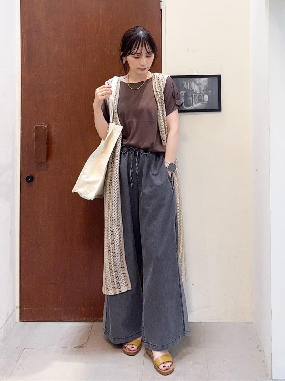 ベージュ系のベスト、ブラウン系のTシャツ/カットソー、ブラック系のデニムパンツを着用したレディースの夏コーディネートの3枚目の写真