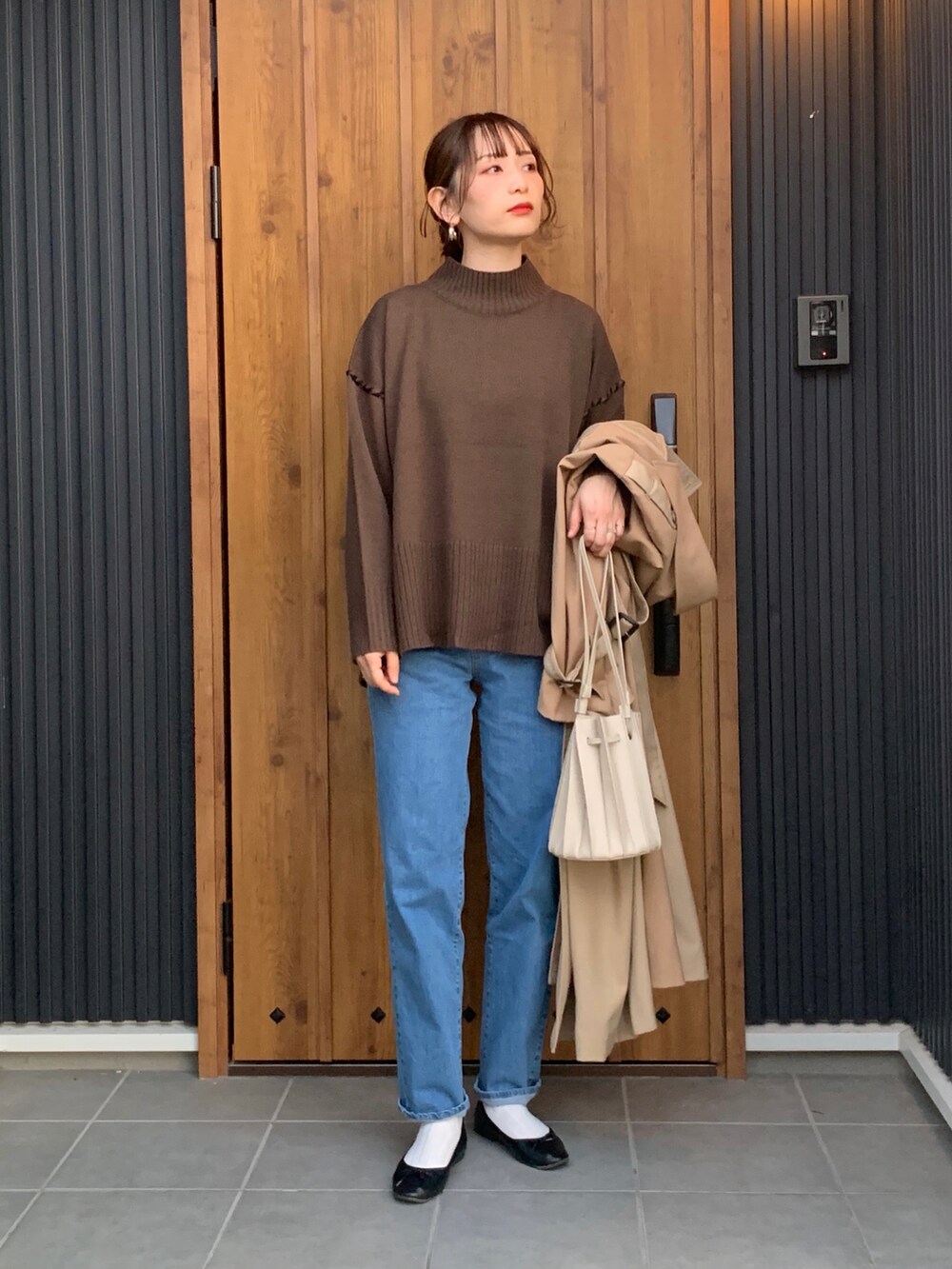 ブラウン系のニット/セーター、ブルー系のデニムパンツを着用したレディースの秋コーディネートの3枚目の写真