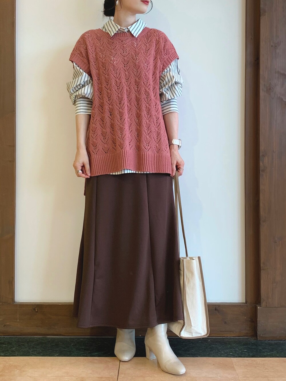グレー系のシャツ/ブラウス、ピンク系のベスト、ブラウン系のスカートを着用したレディースの秋コーディネートの4枚目の写真