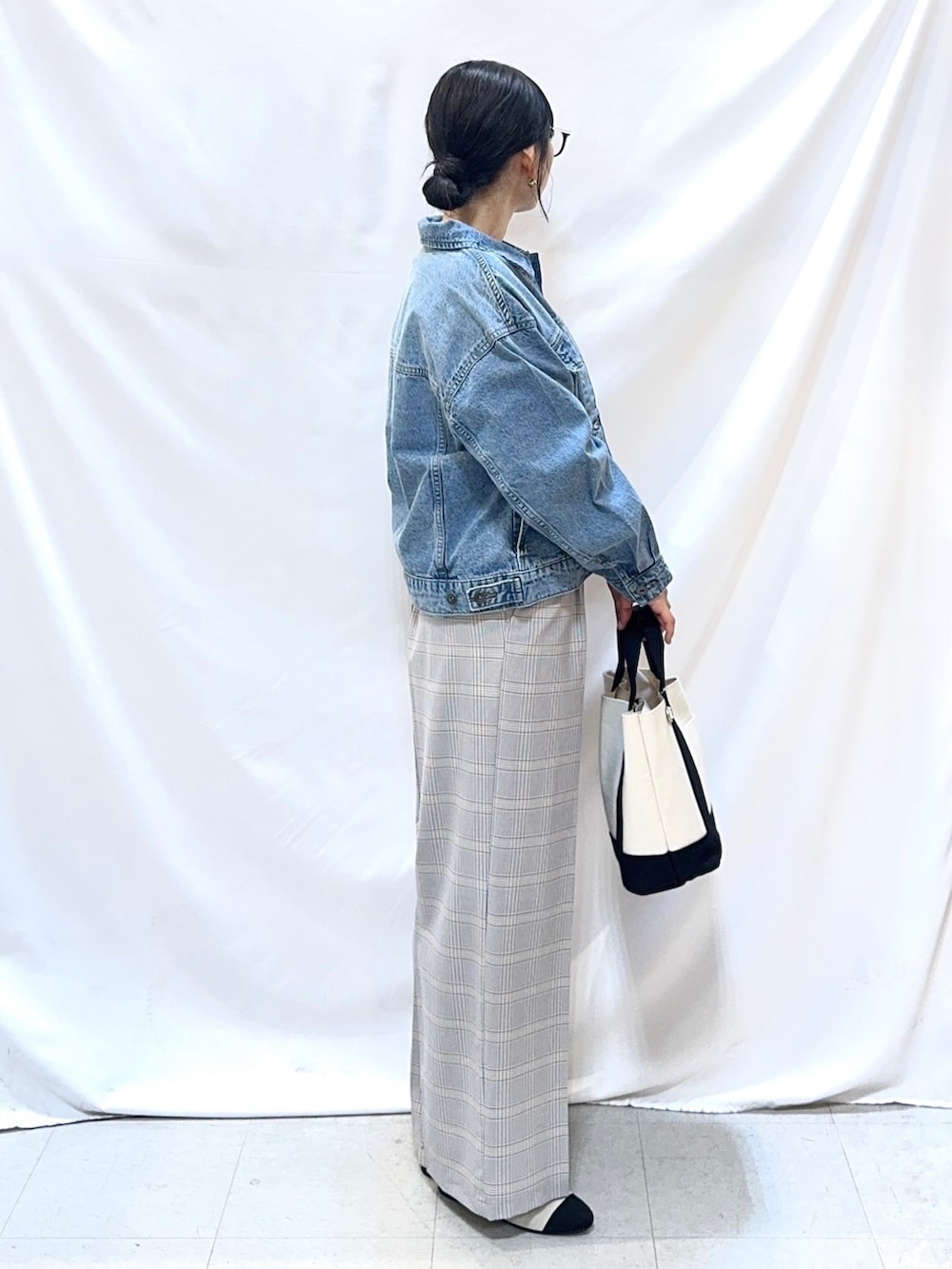 ブルー系のデニムジャケット、グリーン系のニット/セーター、ブルー系のその他パンツを着用したレディースの冬コーディネートの3枚目の写真